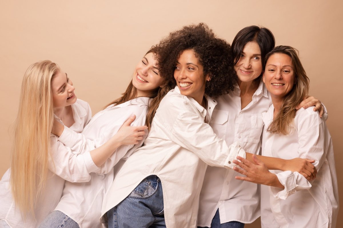 five-diverse-interage-women-wearing-white-shirts-jeans-are-having-fun-against-beige-background-lifestyle-friendship-people-concept